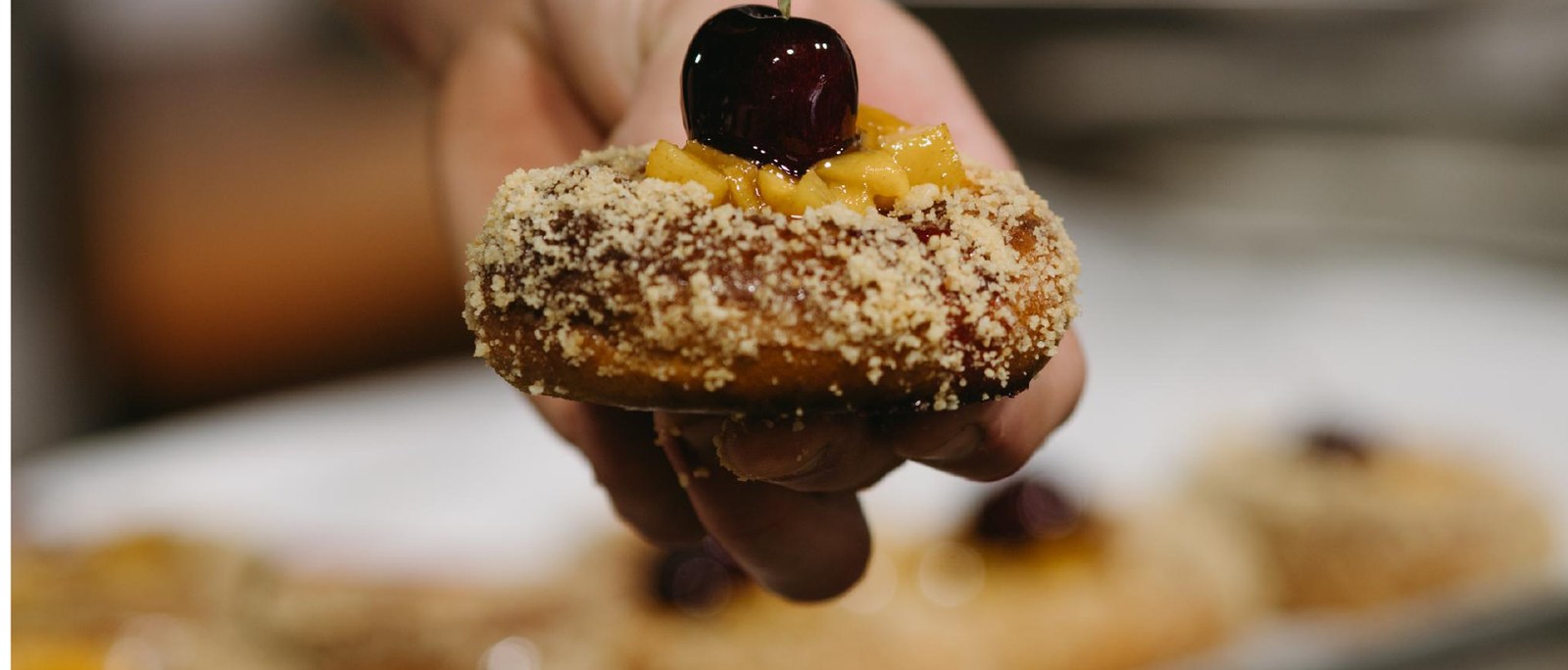 Panellet daurat amb una cirera al damunt, símbol de la pastisseria de territori
